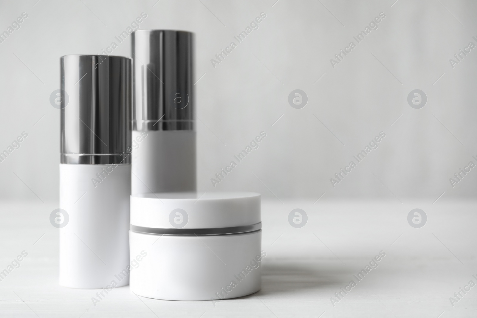 Photo of Set of luxury cosmetic products on white table. Space for text