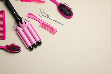 Photo of Flat lay composition of professional hairdresser tools on beige table, space for text