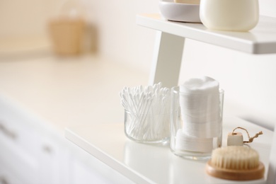 Photo of Cotton buds and pads on shelf in bathroom, space for text