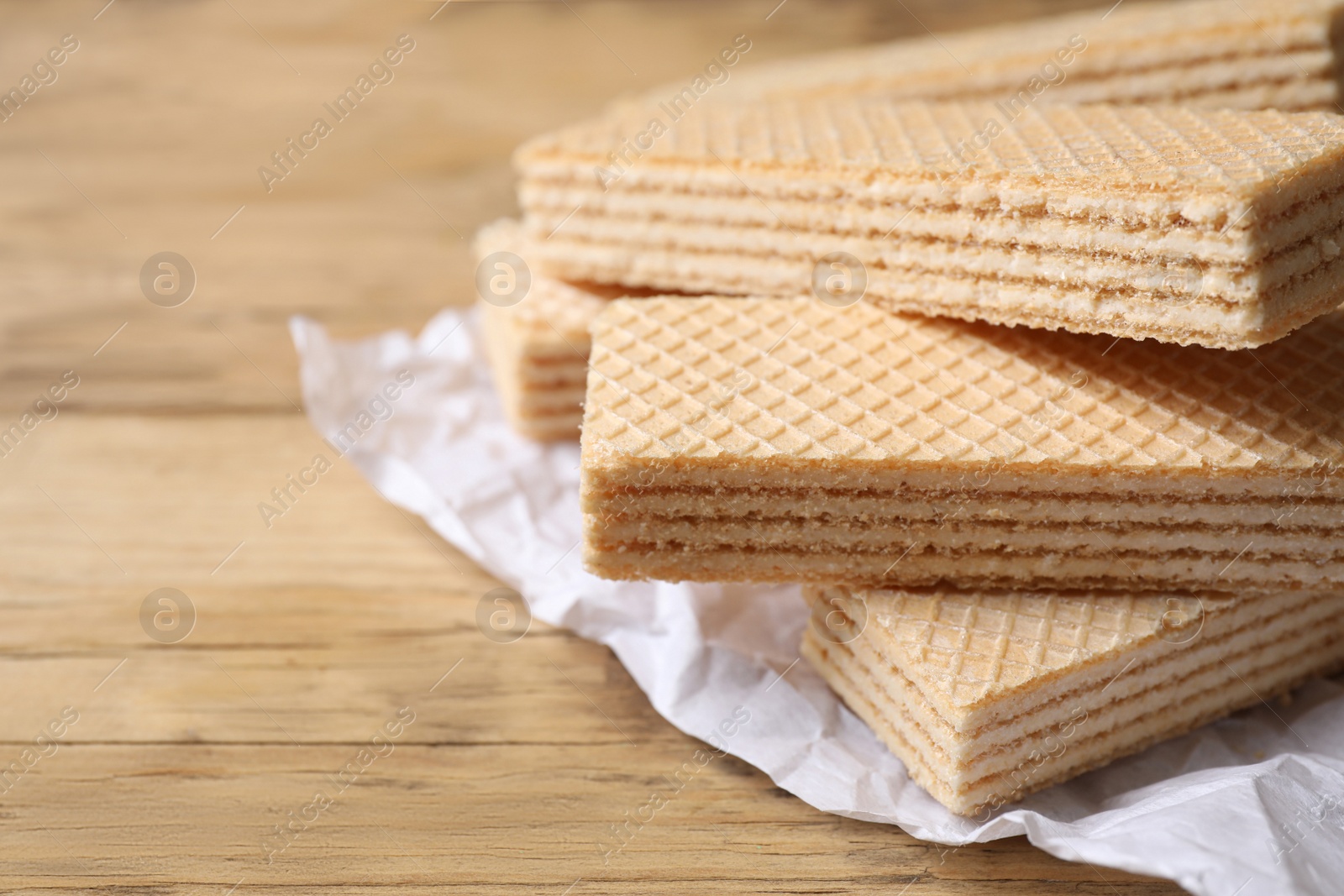 Photo of Delicious cream wafers on wooden table, closeup. Space for text