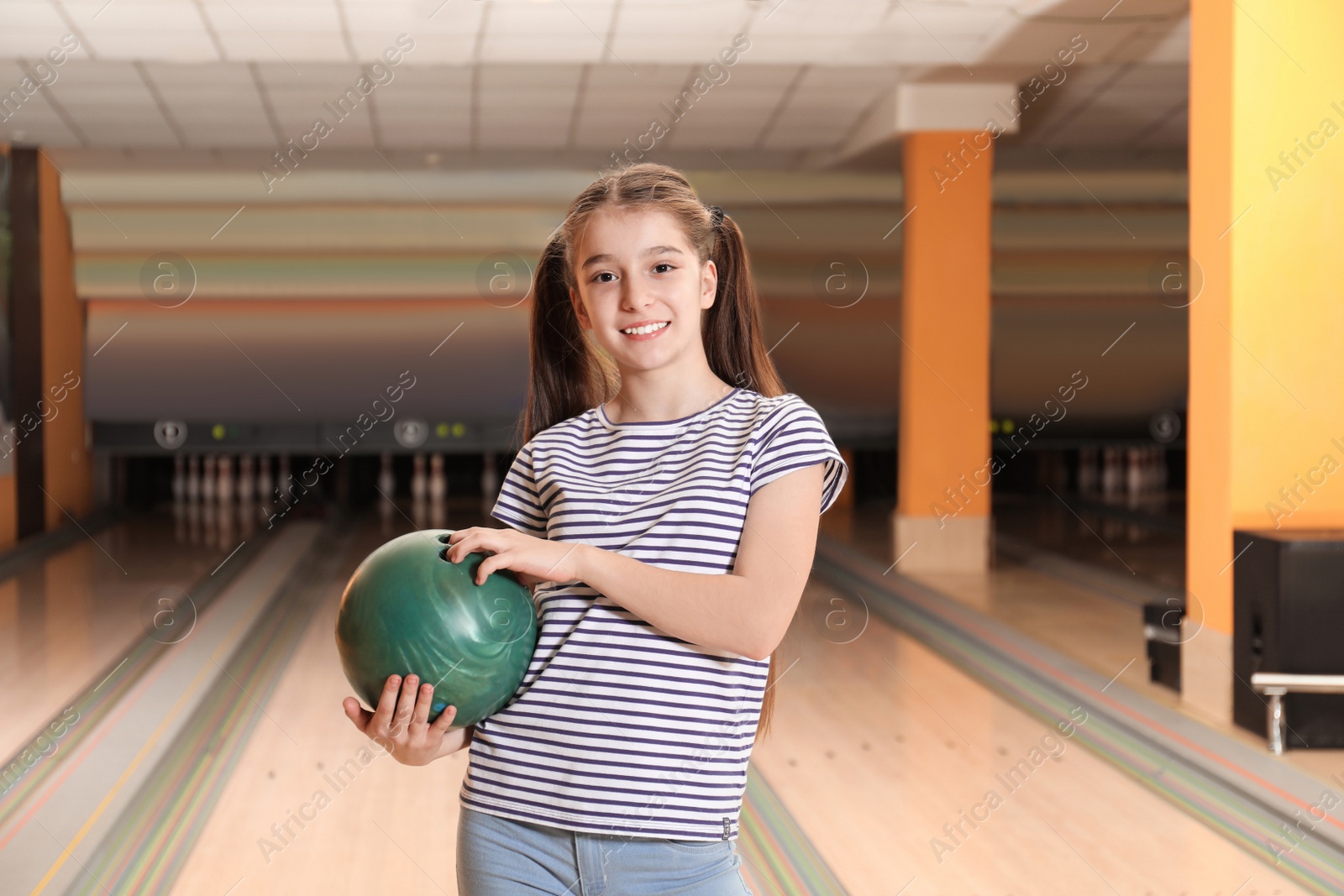 Photo of Preteen girl with ball in bowling club