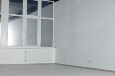 Photo of Blurred view of empty office room with clean window and white walls. Interior design