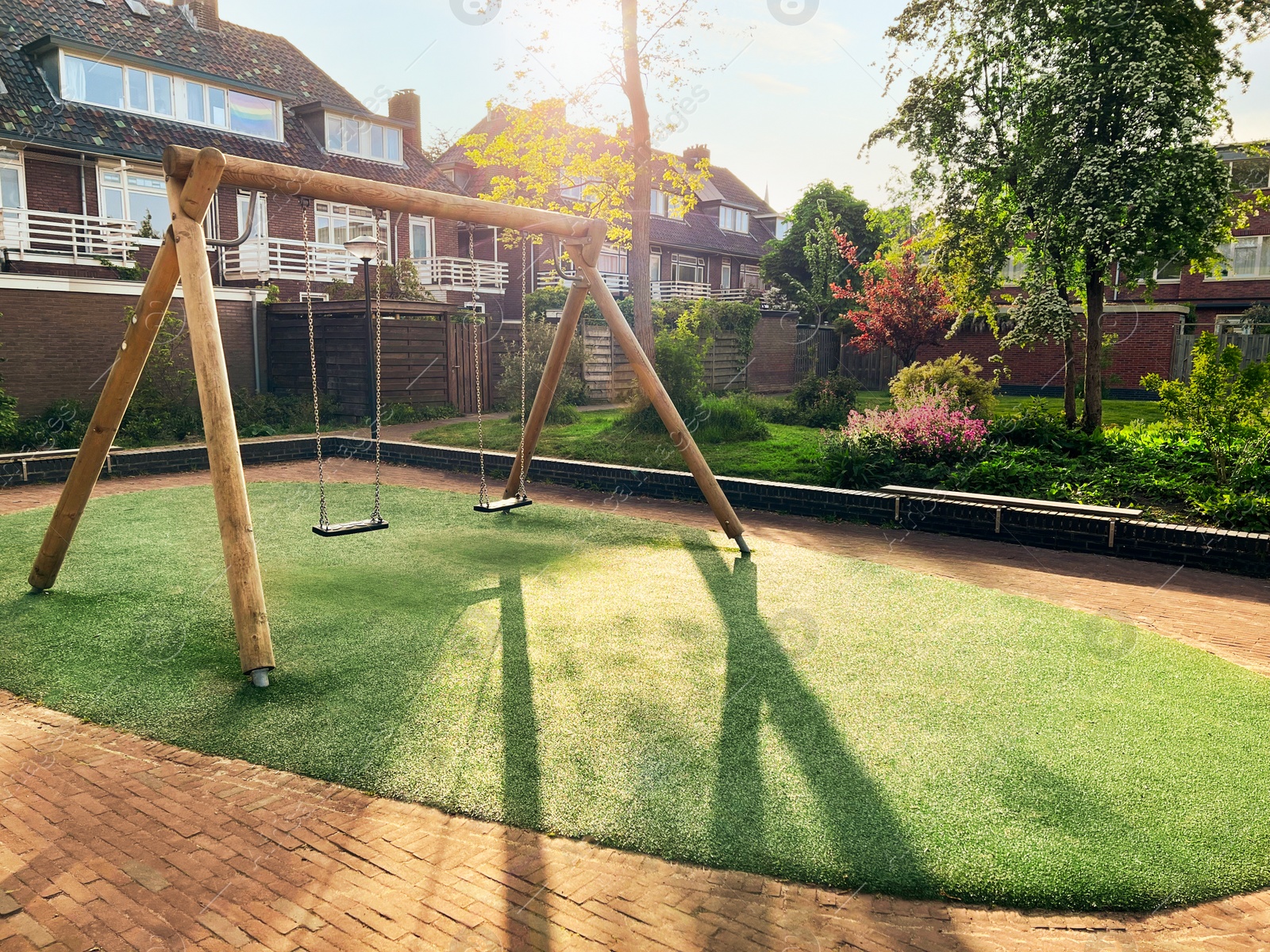 Photo of Outdoor wooden swings at backyard on sunny day