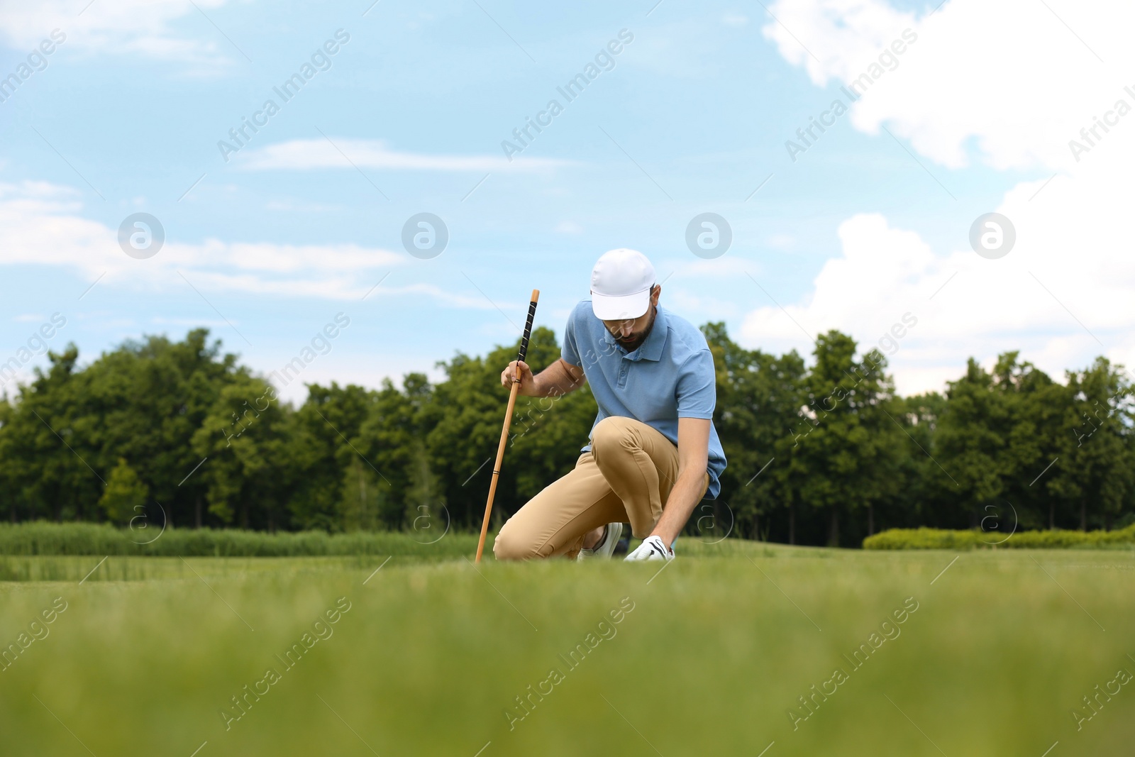 Photo of Man playing golf on green course. Sport and leisure