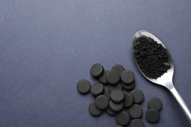 Photo of Activated charcoal pills on grey background, flat lay with space for text. Potent sorbent