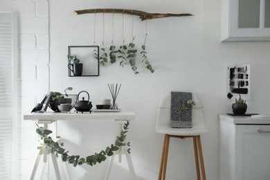 Stylish room decorated with beautiful green eucalyptus branches