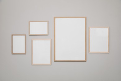 Photo of Empty frames on grey wall. Mockup for design