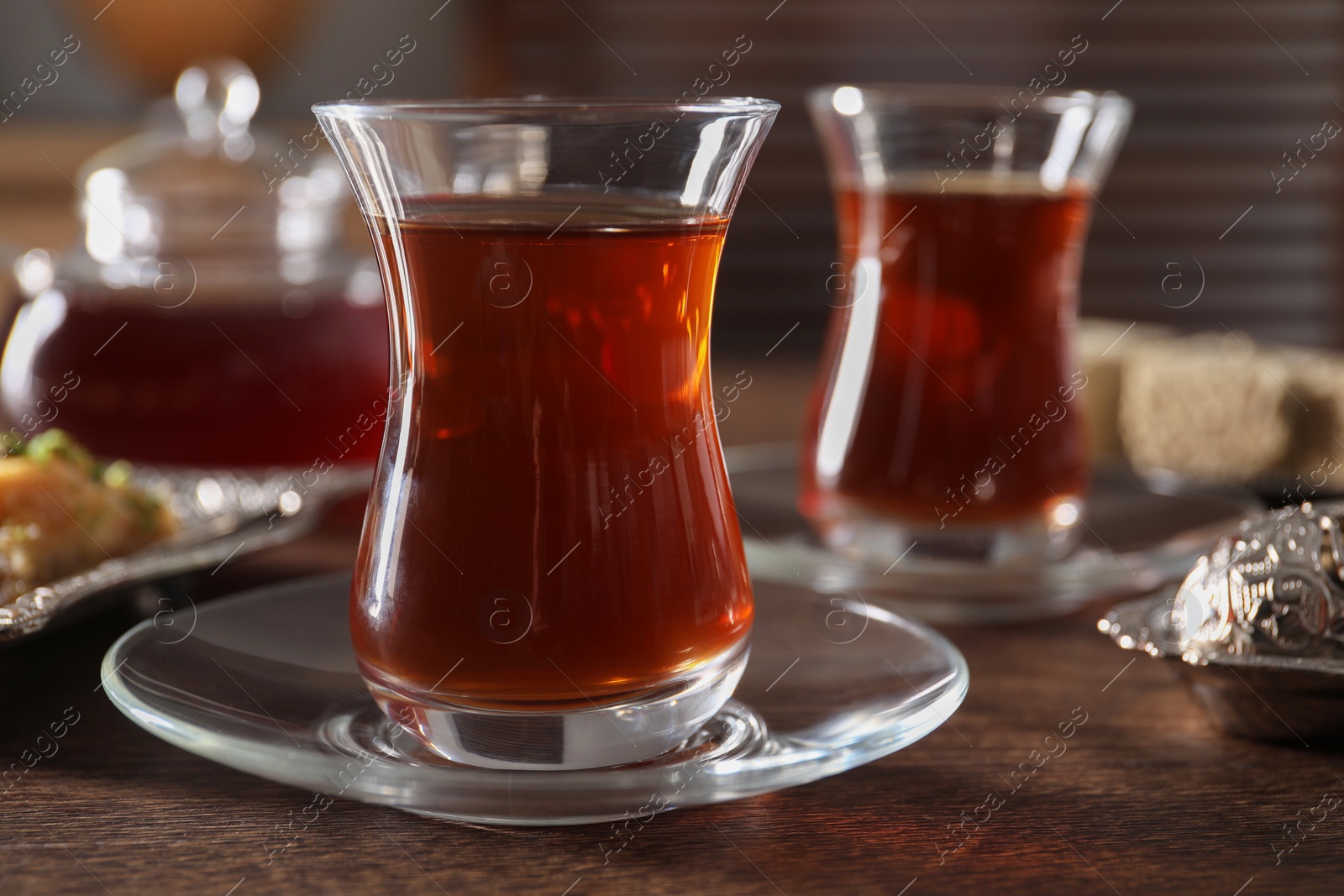 Photo of Traditional Turkish tea in glasses on wooden table, closeup