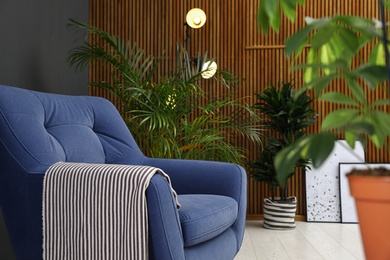 Room interior with armchair and indoor plants. Trendy home decor