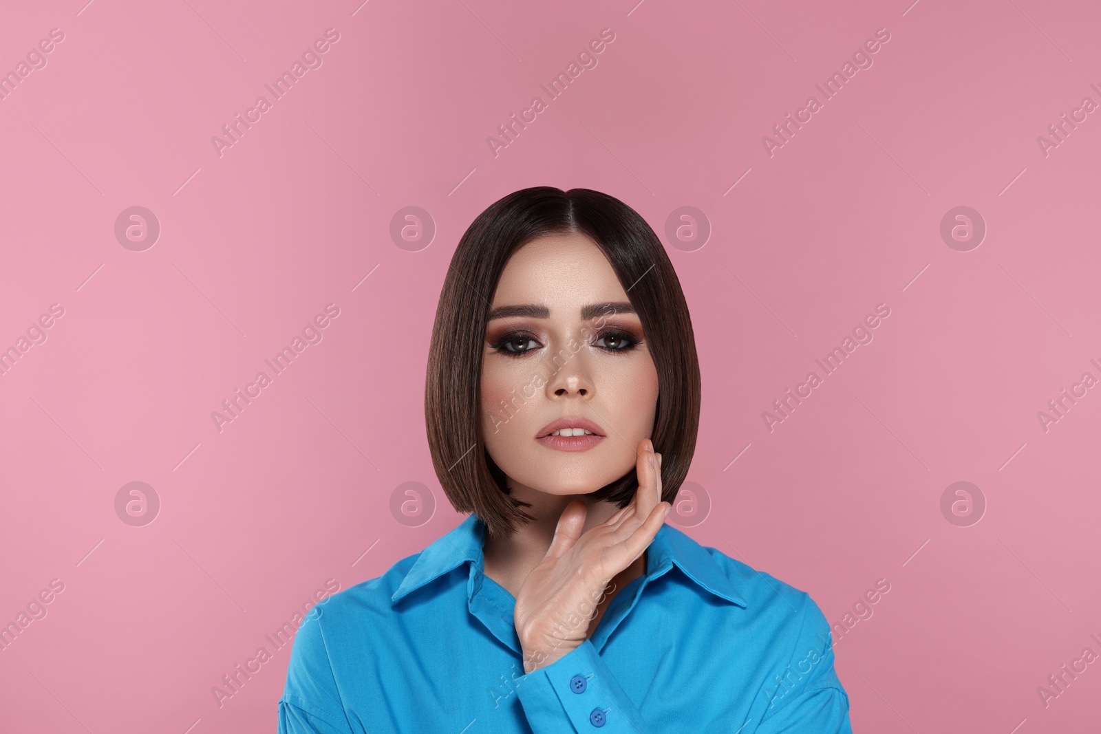 Image of Portrait of stylish pretty young woman with brown hair on pink background