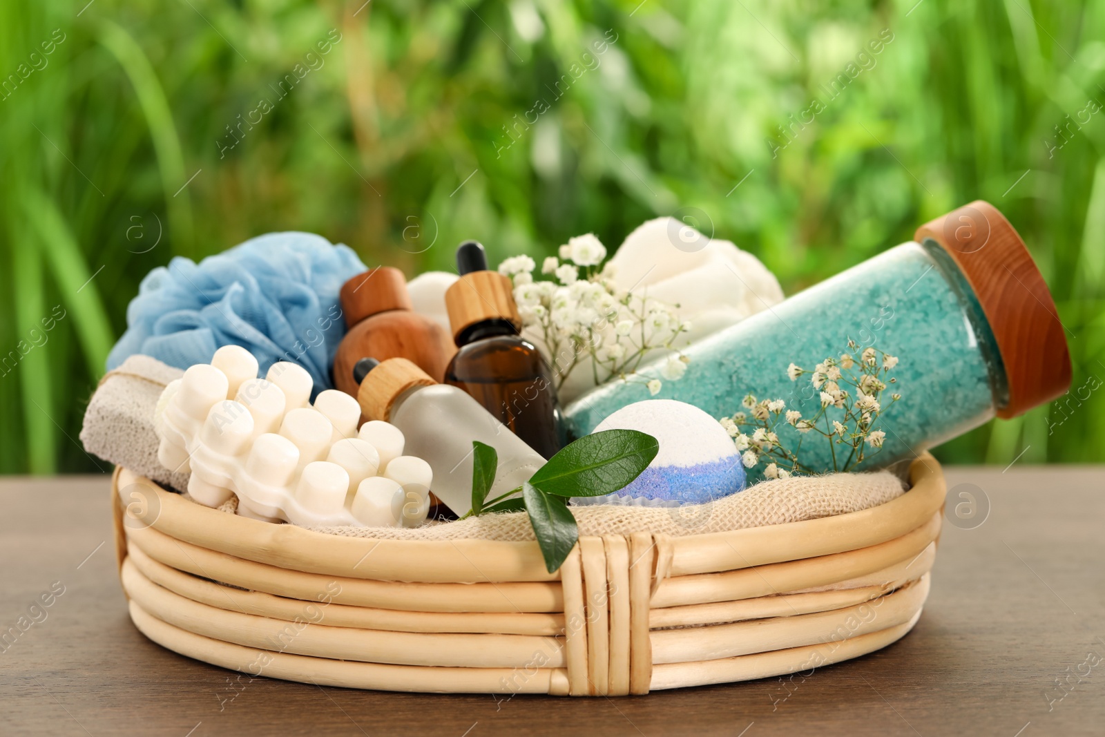 Photo of Spa gift set with different products on wooden table against blurred background