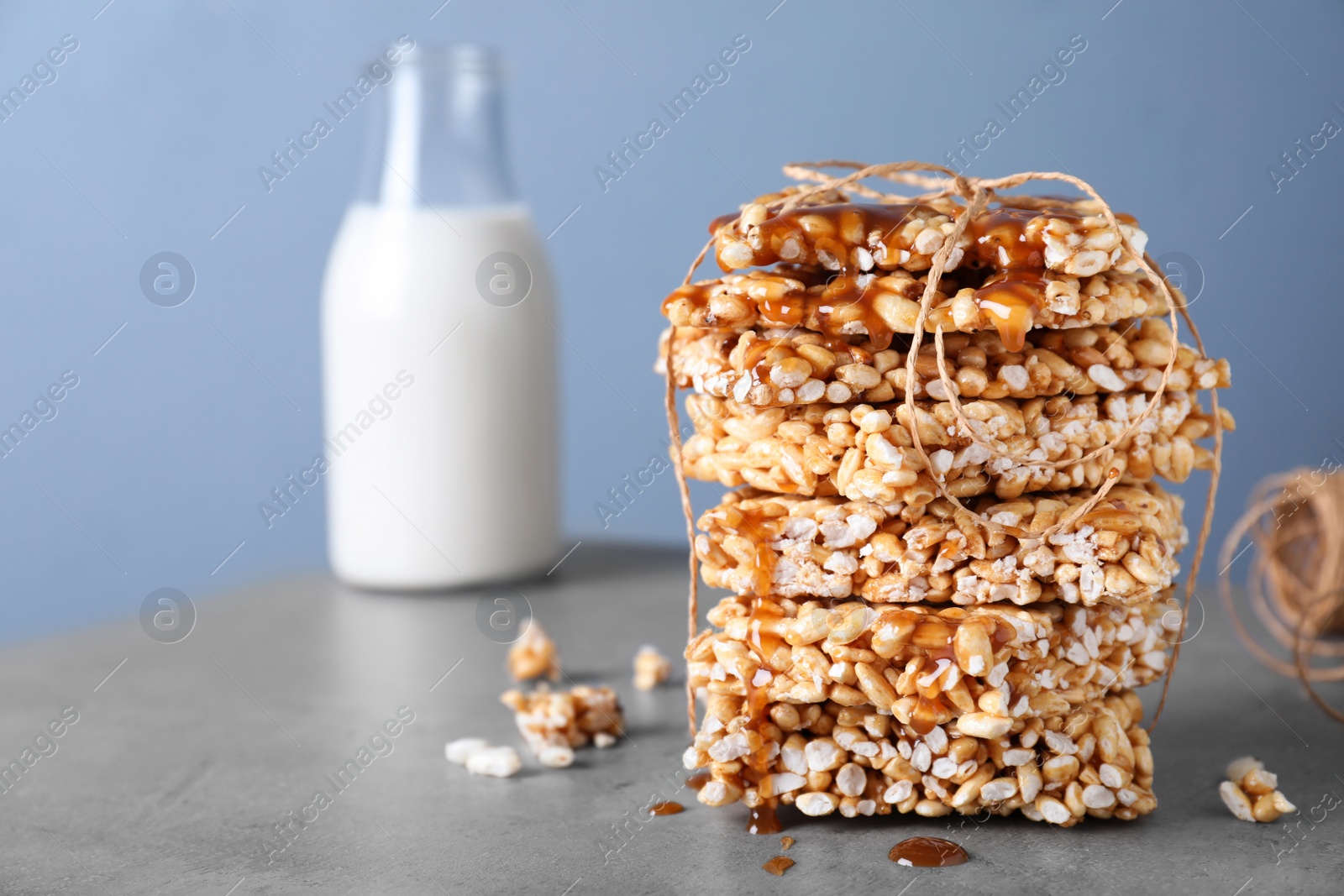 Photo of Delicious rice crispy treats on grey table. Space for text