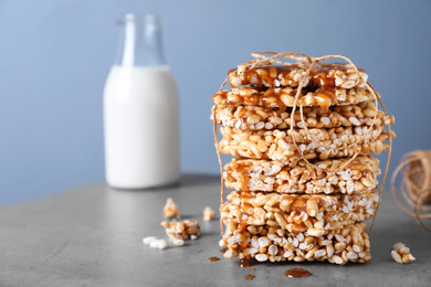 Photo of Delicious rice crispy treats on grey table. Space for text