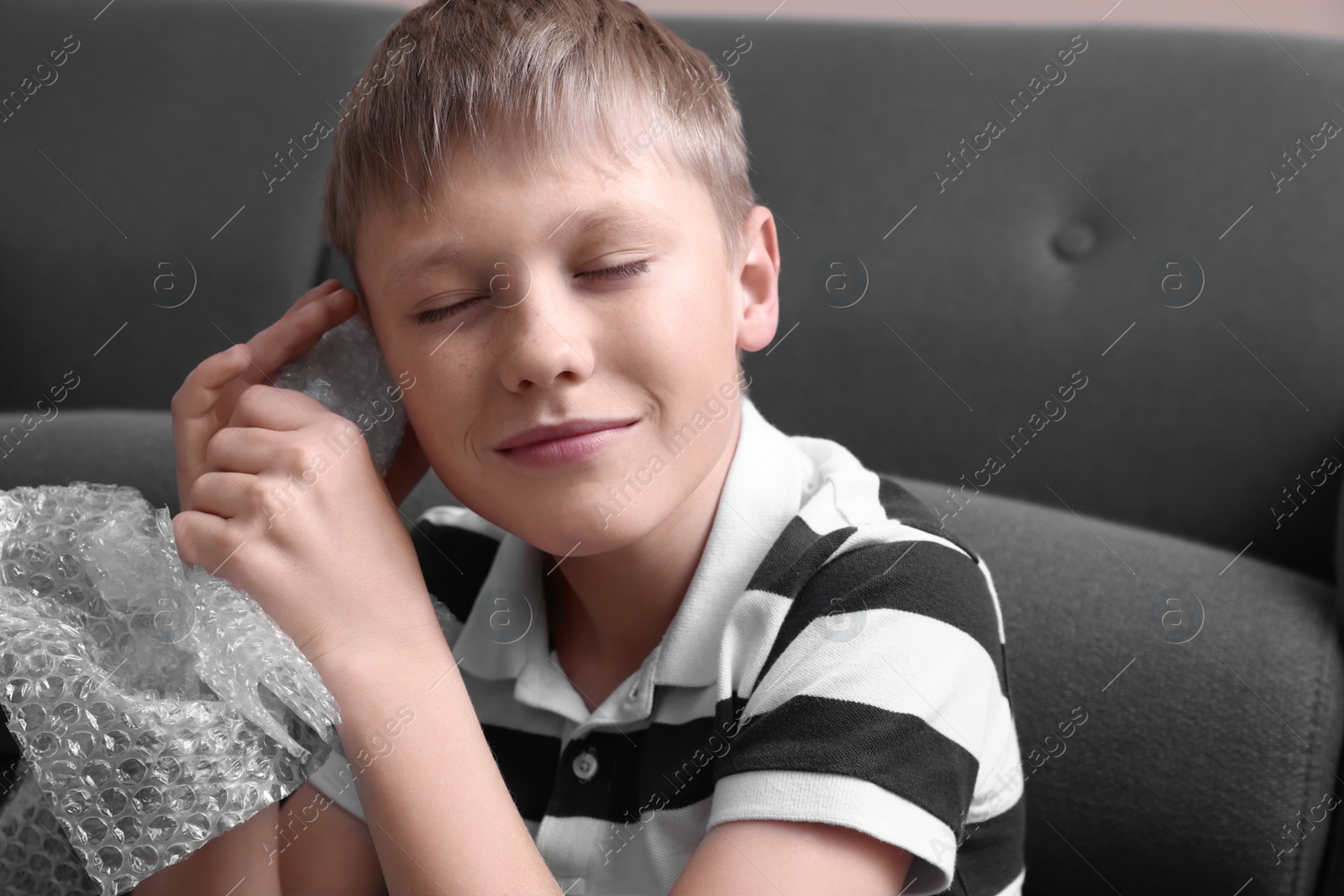 Photo of Boy popping bubble wrap at home. Stress relief