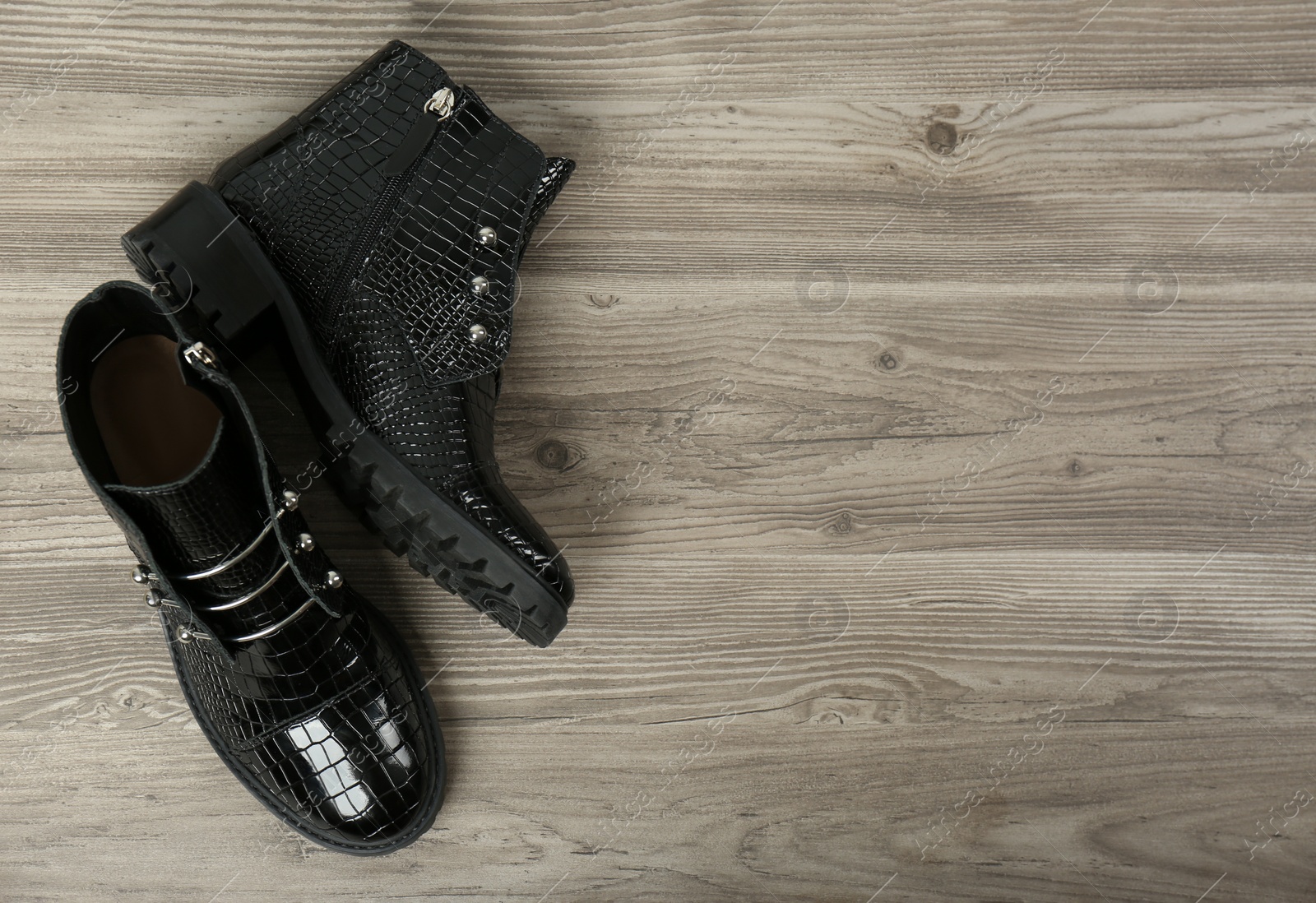 Photo of Pair of stylish ankle boots on wooden background, top view. Space for text