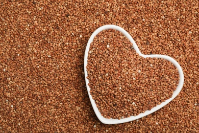 Heart shaped plate with buckwheat on grains, top view. Space for text