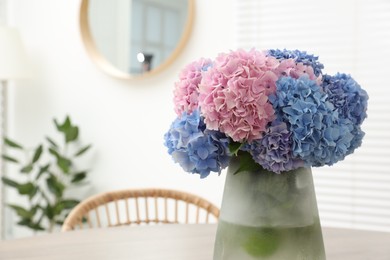 Vase with beautiful hydrangea flowers on table indoors. Space for text