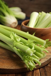 Photo of Fresh green celery bunches on wooden table, closeup
