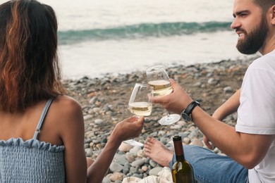 Photo of Young couple having picnic on beach near sea