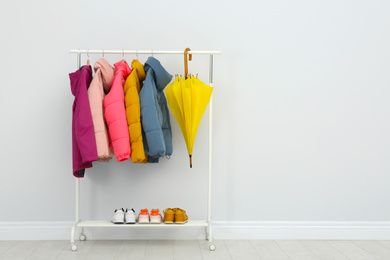 Rack with warm jackets in room. Space for text