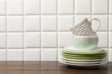 Beautiful ceramic dishware and cup on wooden table, space for text