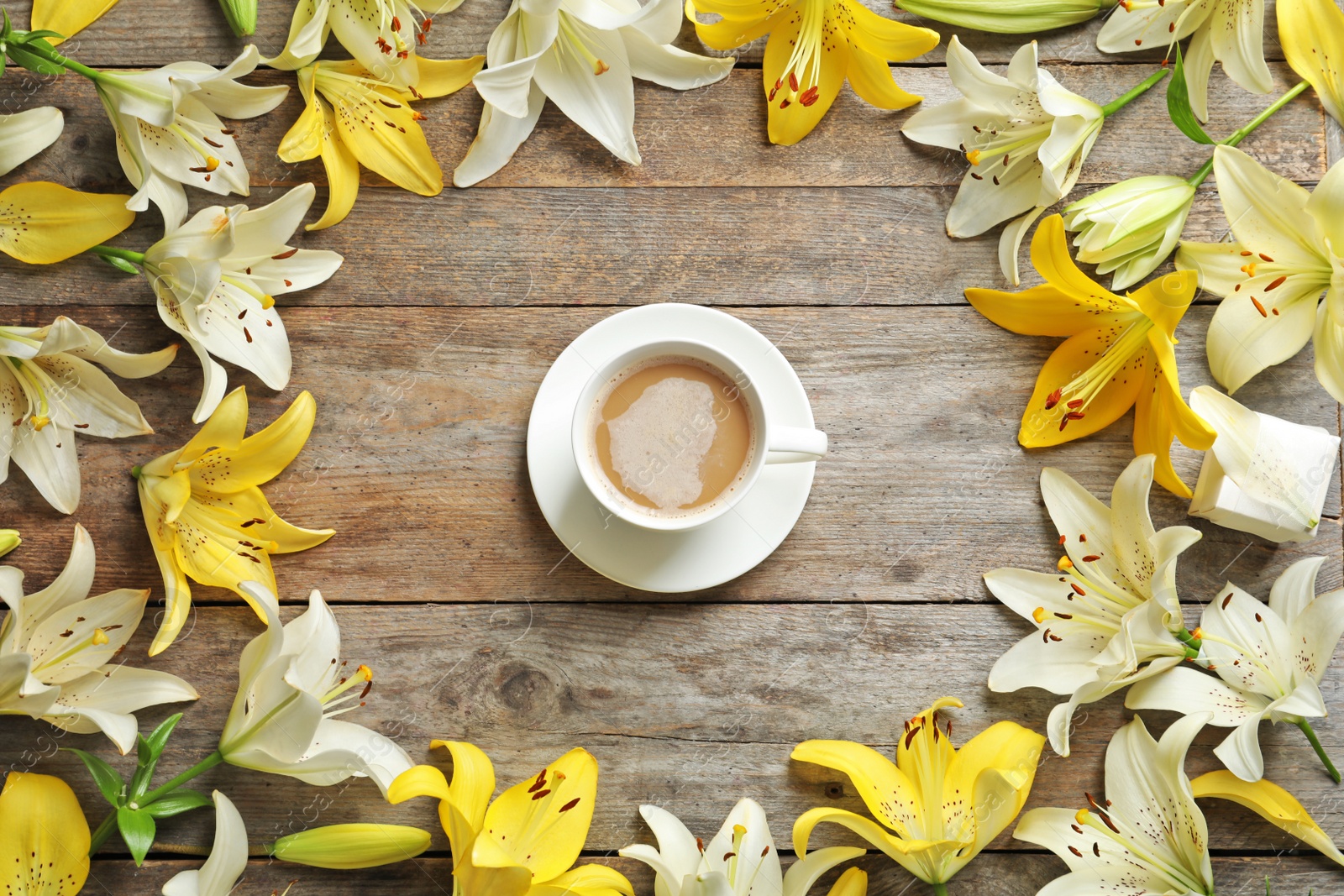 Photo of Flat lay composition with lily flowers and cup of coffee on wooden background