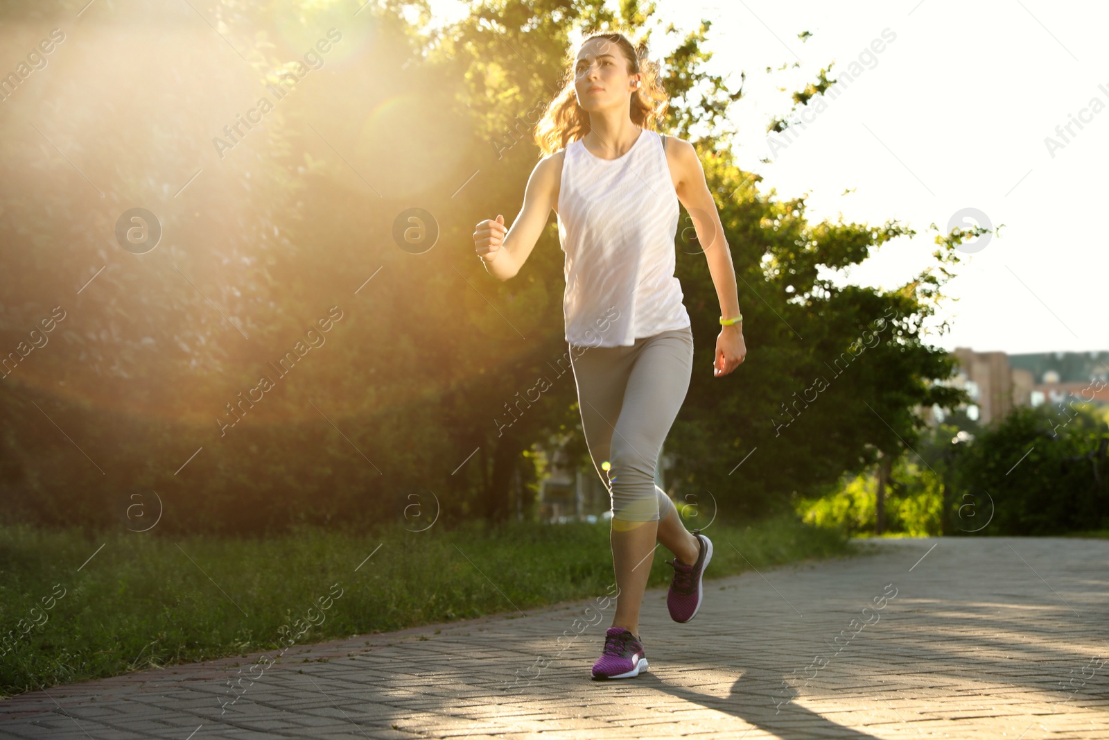 Photo of Young woman running in park on sunny day, space for text