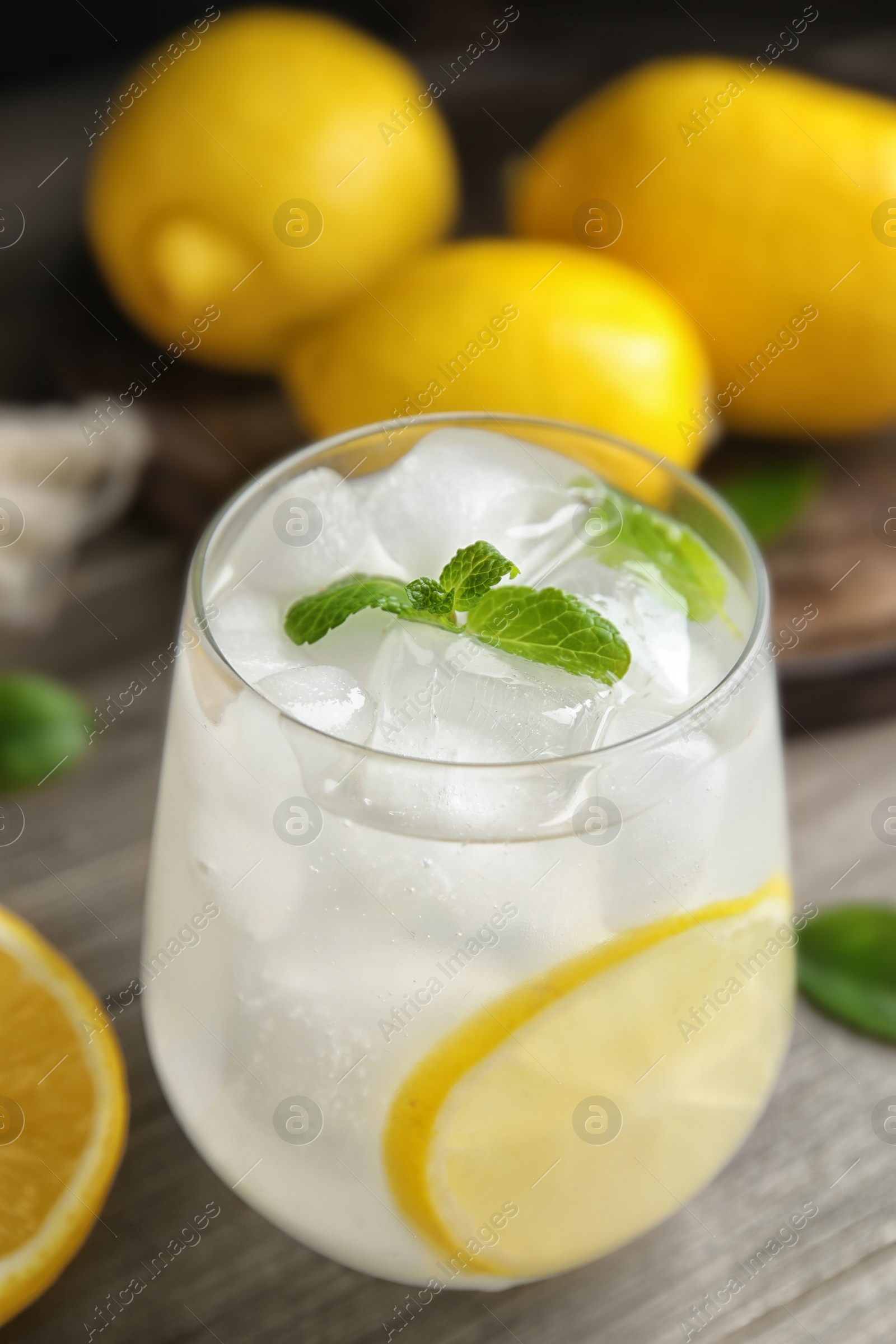 Photo of Cool freshly made lemonade in glass on wooden table, closeup