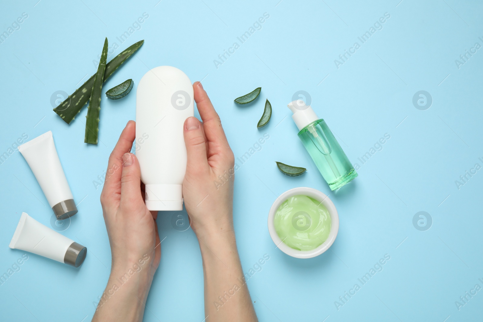 Photo of Woman with different cosmetic products and aloe on light blue background, flat lay