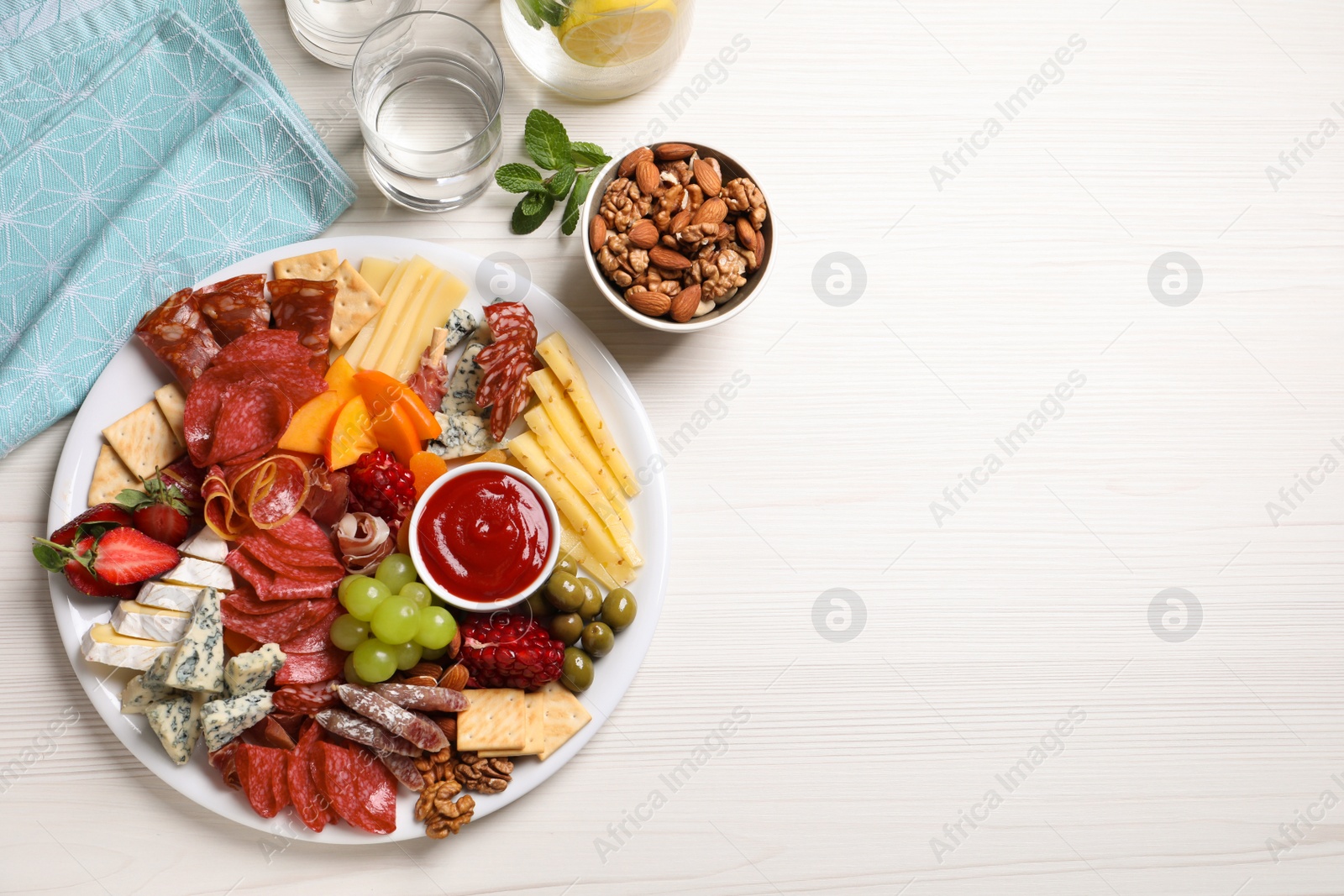 Photo of Plate of different appetizers with dip sauce on white wooden table, flat lay. Space for text