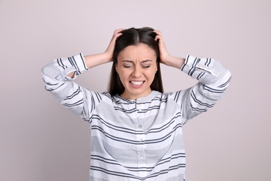 Photo of Portrait of stressed young woman on light background