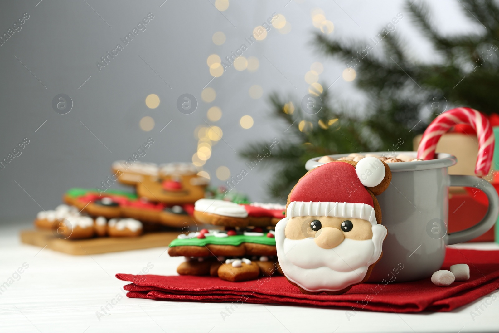 Photo of Tasty homemade Christmas cookies and hot drink with candy cane on white table. Space for text