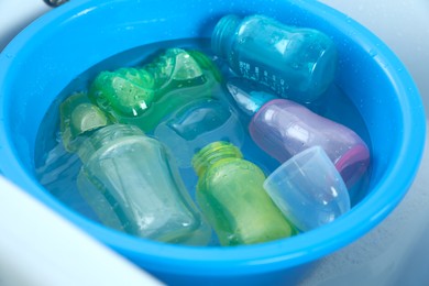 Photo of Light blue basin with baby bottles, closeup