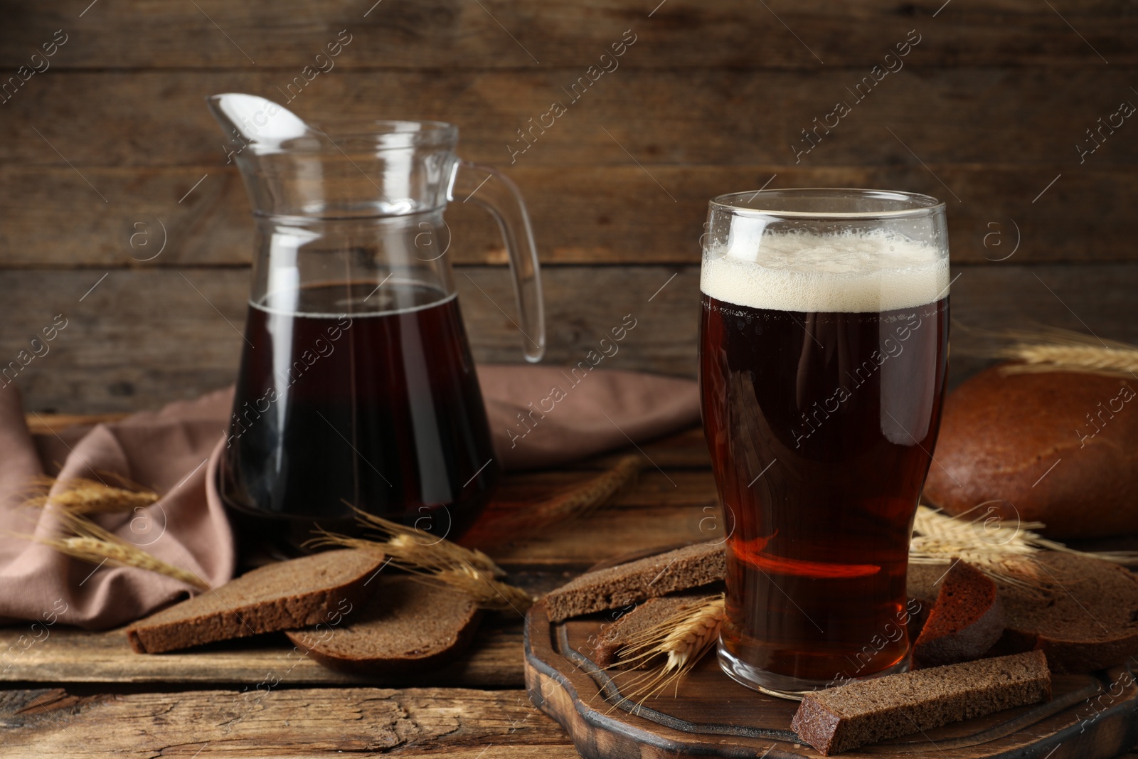 Photo of Composition with delicious kvass, spikes and bread on wooden table