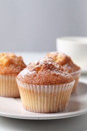 Photo of Delicious sweet muffins on white table, closeup. Space for text