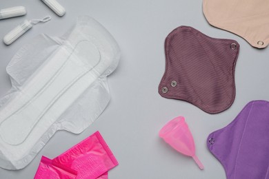 Photo of Different menstrual hygiene products on grey background, flat lay