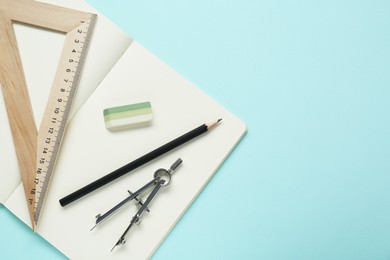 Different rulers, pencil, compass and notebook on turquoise background, flat lay. Space for text