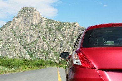 Beautiful view of mountains and car on asphalt highway outdoors, closeup. Road trip