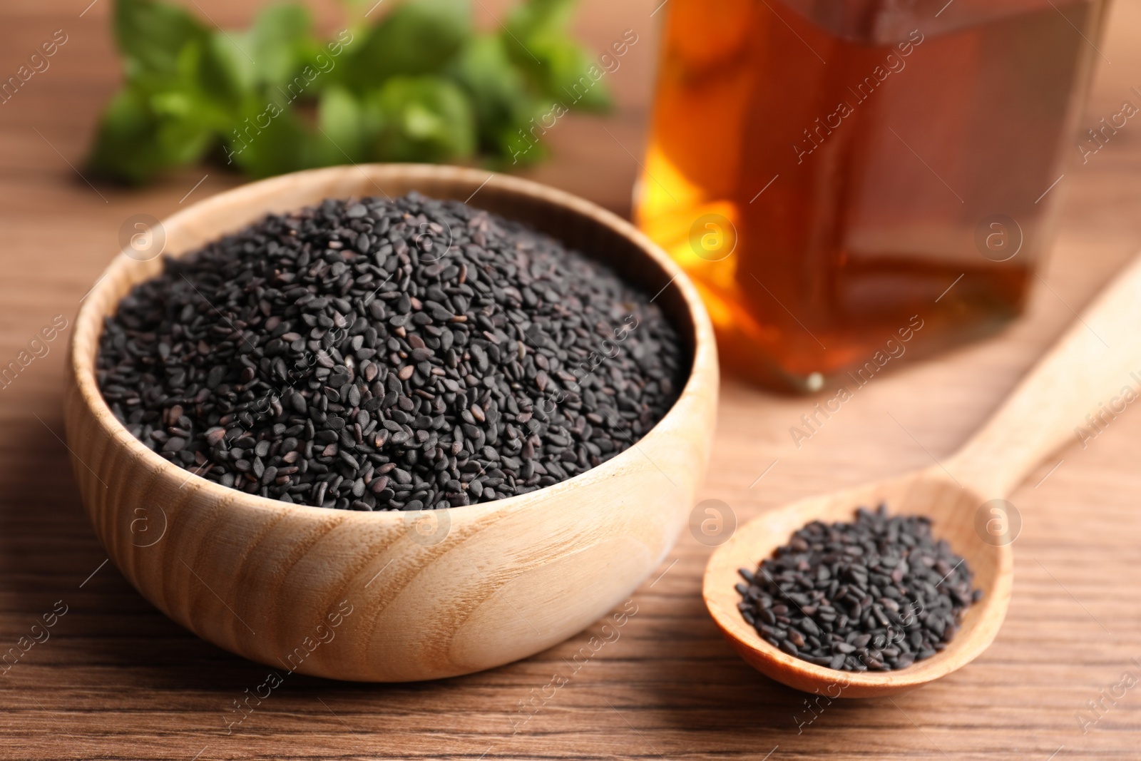 Photo of Black sesame seeds on wooden table, closeup