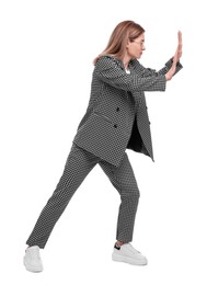 Photo of Beautiful businesswoman in suit pushing something on white background