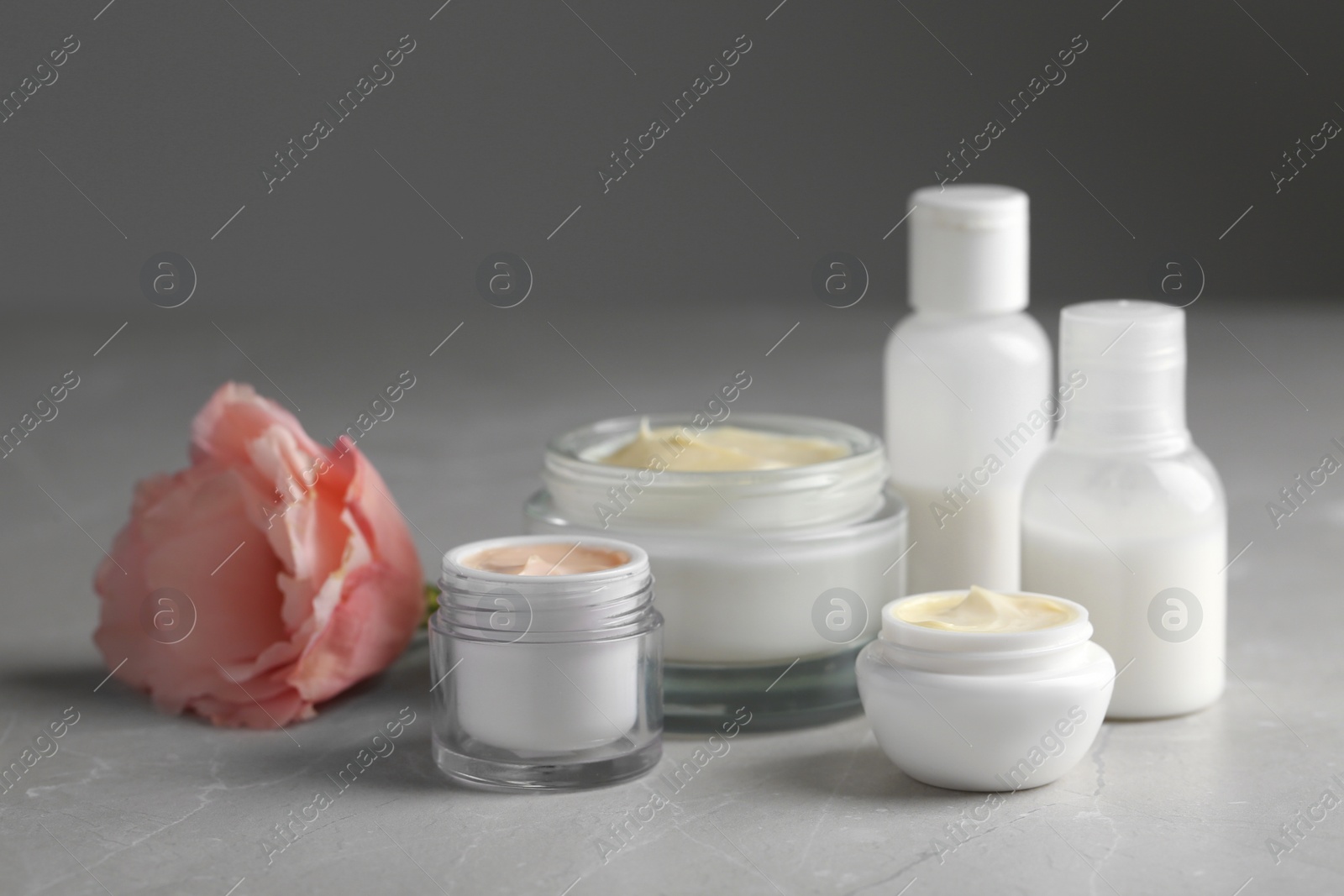 Photo of Jars with cream and bottles on light table. Hand care cosmetics