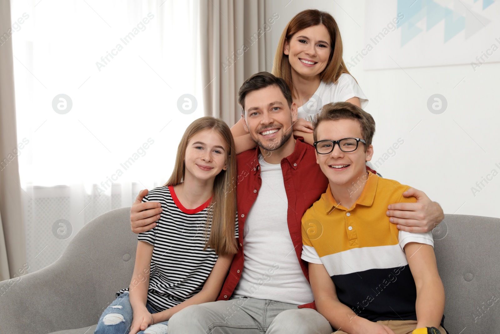 Photo of Happy parents with their teenager children at home