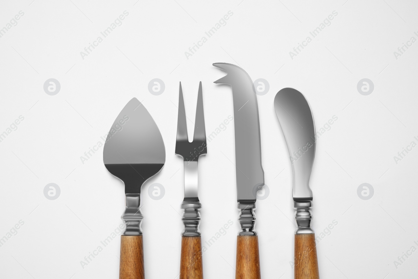 Photo of Cheese knives and fork on white background, top view