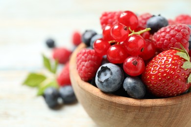 Photo of Mix of different fresh berries in bowl on table, closeup. Space for text