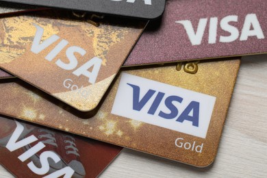 MYKOLAIV, UKRAINE - FEBRUARY 22, 2022: Visa credit cards on white wooden table, closeup