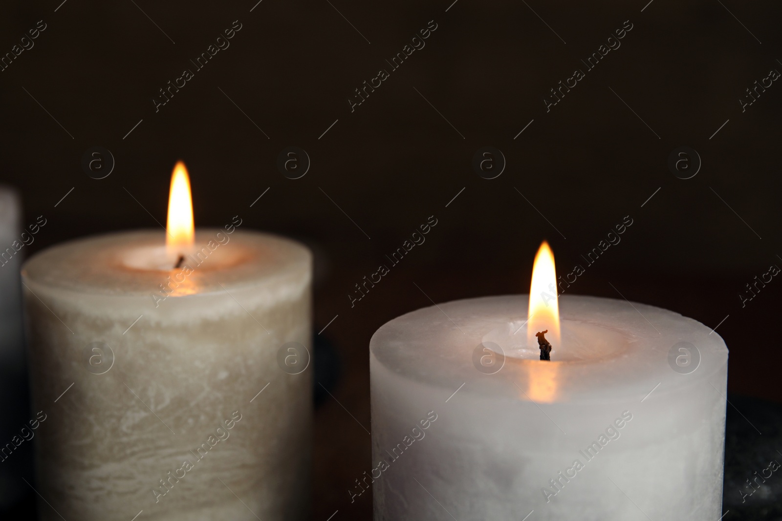 Photo of Burning aromatic candles on dark background, closeup