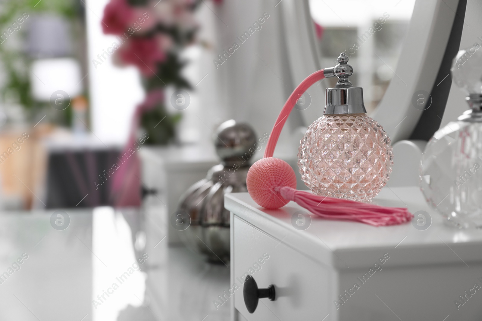 Photo of Bottles of perfumes on white dressing table