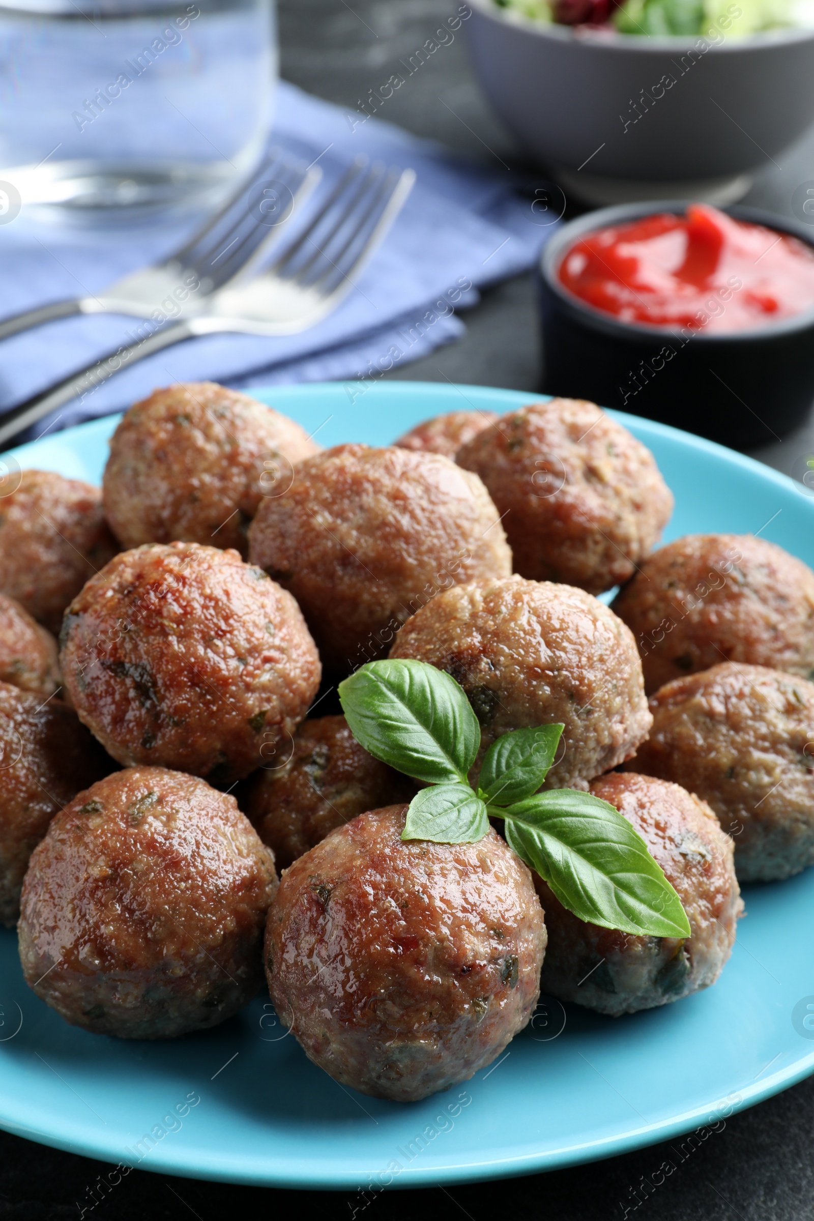 Photo of Tasty cooked meatballs and basil on plate