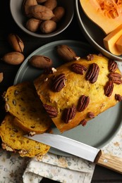Delicious pumpkin bread with pecan nuts on wooden table, flat lay