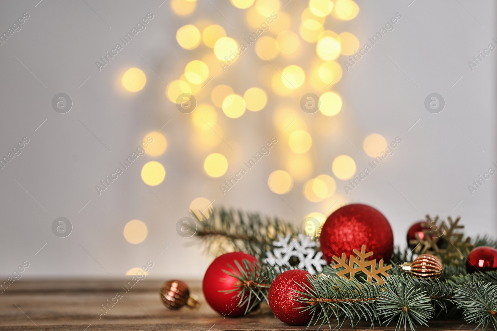 Photo of Christmas decoration on table against blurred lights. Space for text